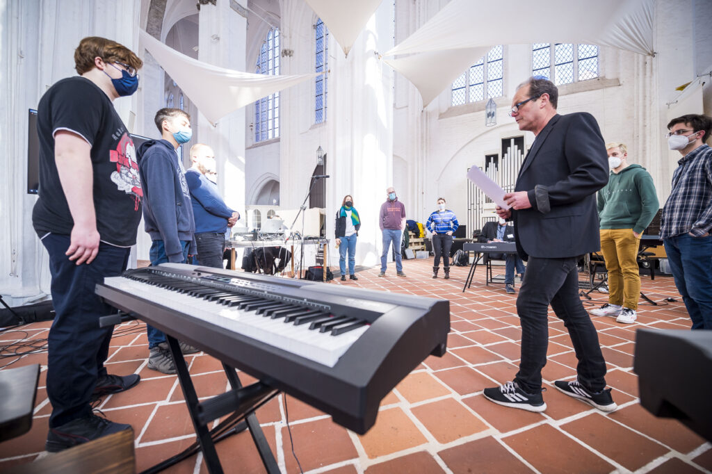 Schüler*innen und Studierende erarbeiten in der Kulturkirche St. Petri eine Performance. Im Vordergrund steht ein Keyboard. Foto: O. Malzahn